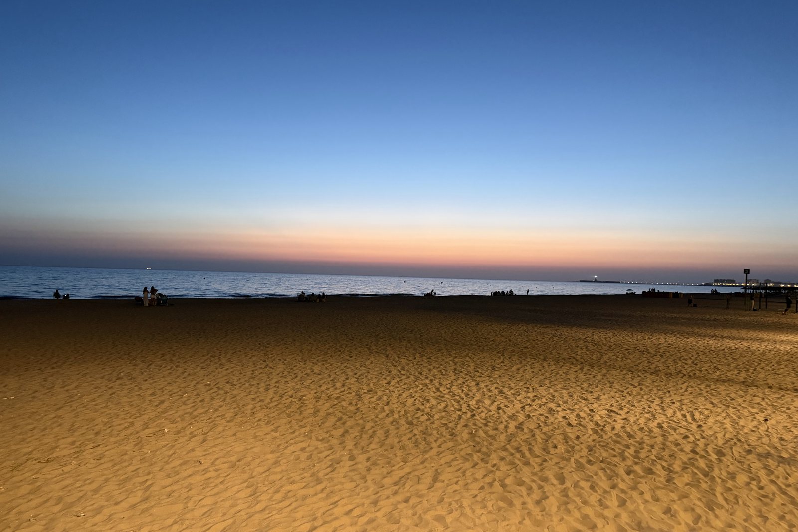 Amanecer sobre la playa con la arena en primer plano
